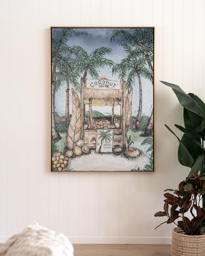 Coconut Hut tropical still life fine art print by Stephanie Elizabeth, framed canvas in an oak frame in a living room