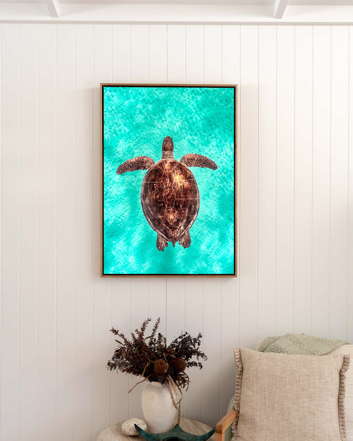 Copper Glow – Green Sea Turtle, Underwater Photography by David Lloyd, framed canvas print in oak float frame, styled in a bedroom setting