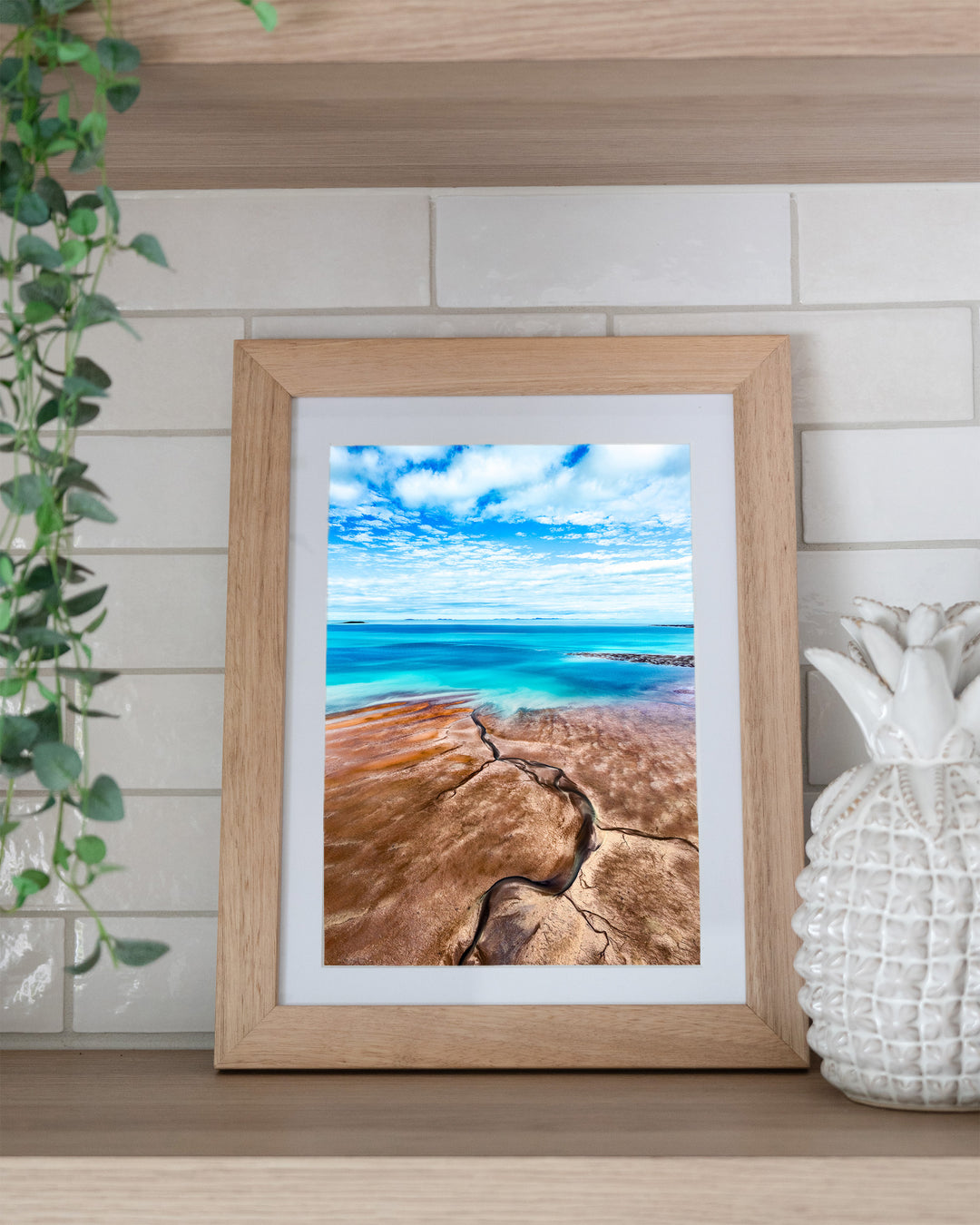 Cracks in the Ocean – Ocean Art, Aerial Photography by David Lloyd, framed paper print in oak frame, styled in a kitchen shelf setting