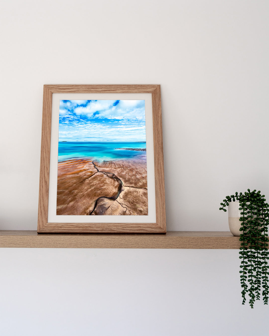 Cracks in the Ocean – Ocean Art, Aerial Photography by David Lloyd, framed paper print in oak frame, styled in a timber shelf setting