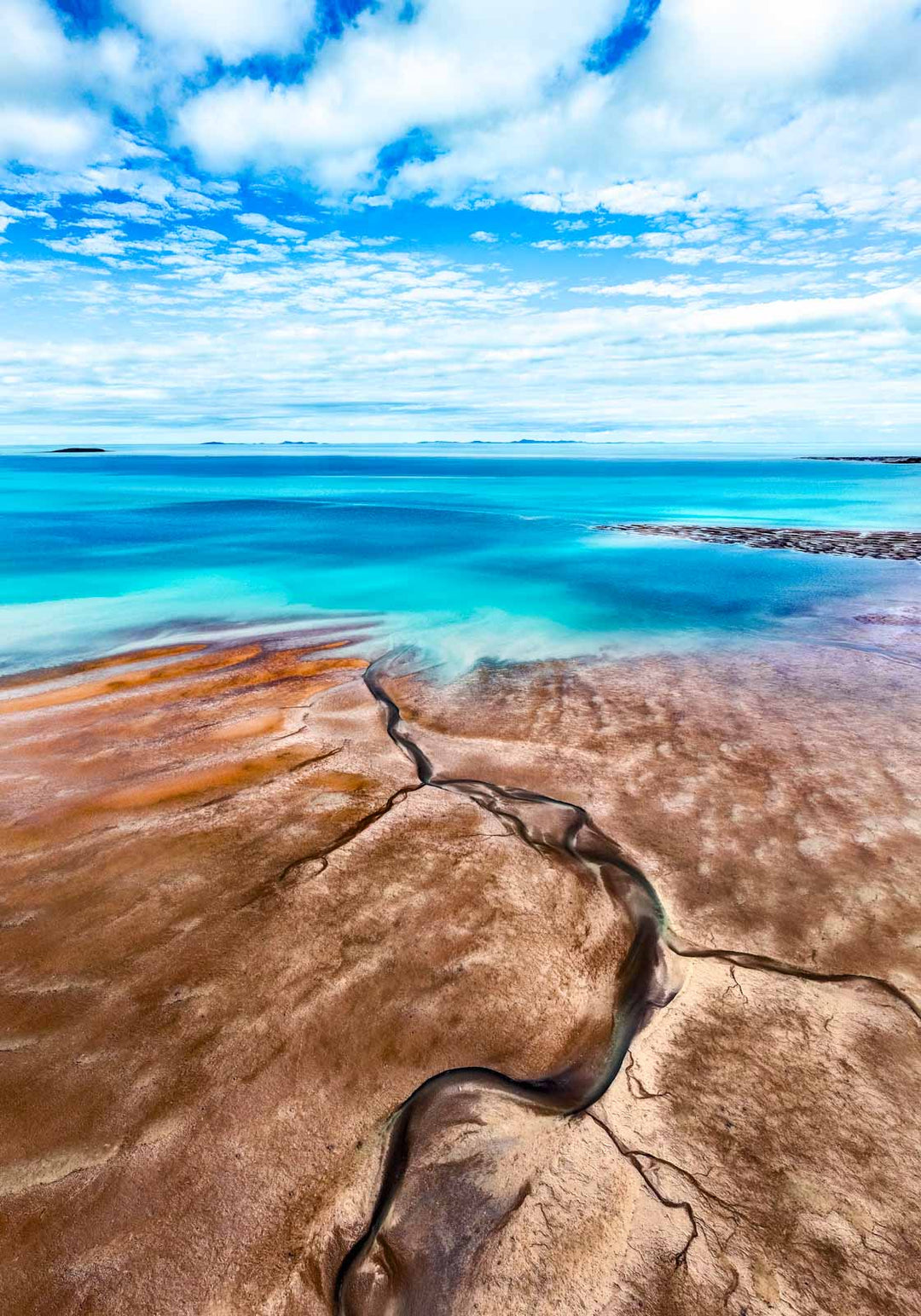 Cracks in the Ocean – Aerial view of textured brown sands and vivid blue ocean, low tide leading lines creating natural patterns | Unframed Rolled Print