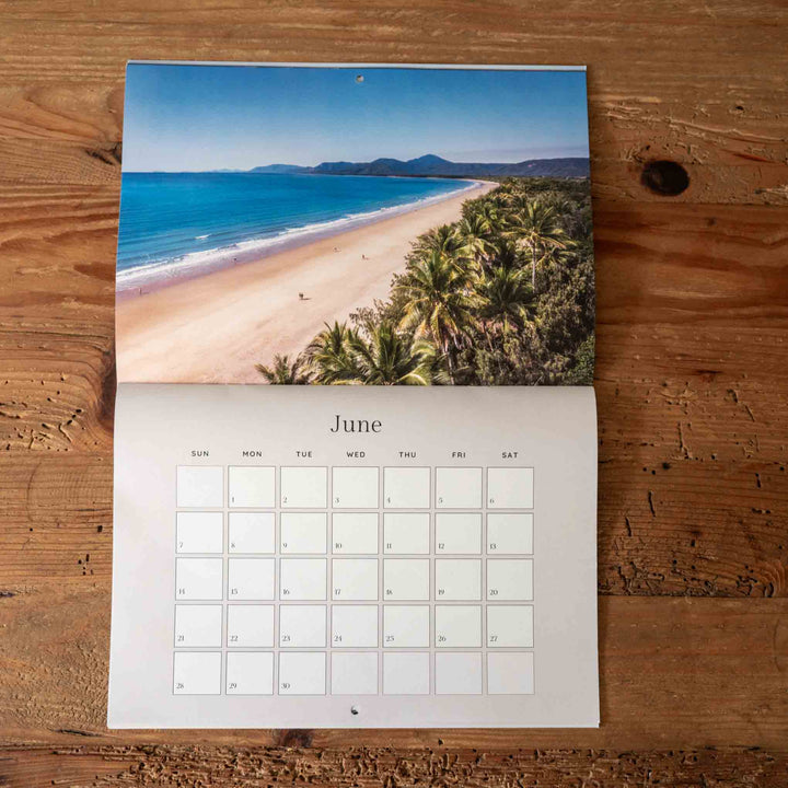 Calendar with a beach and palm tree design on a wooden surface