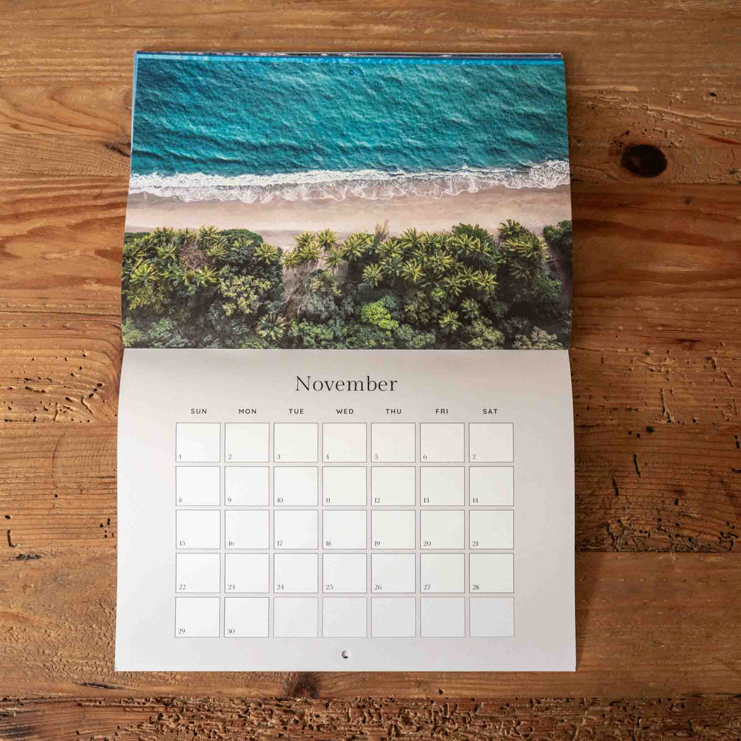 Calendar for November showing a beach scene on a wooden surface