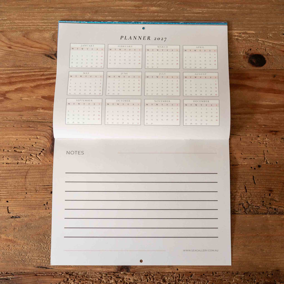 Planner with calendar and notes section on a wooden surface