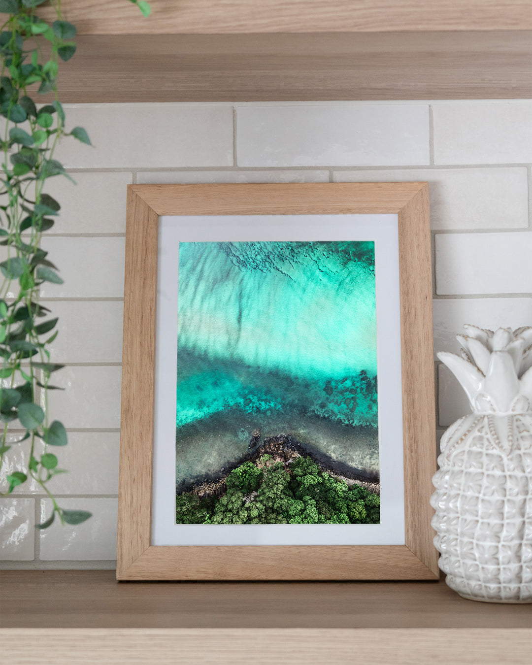 Don’t Dream It’s Over – Cape Tribulation, Aerial Photography by David Lloyd, framed paper print in oak frame, styled in a kitchen shelf setting
