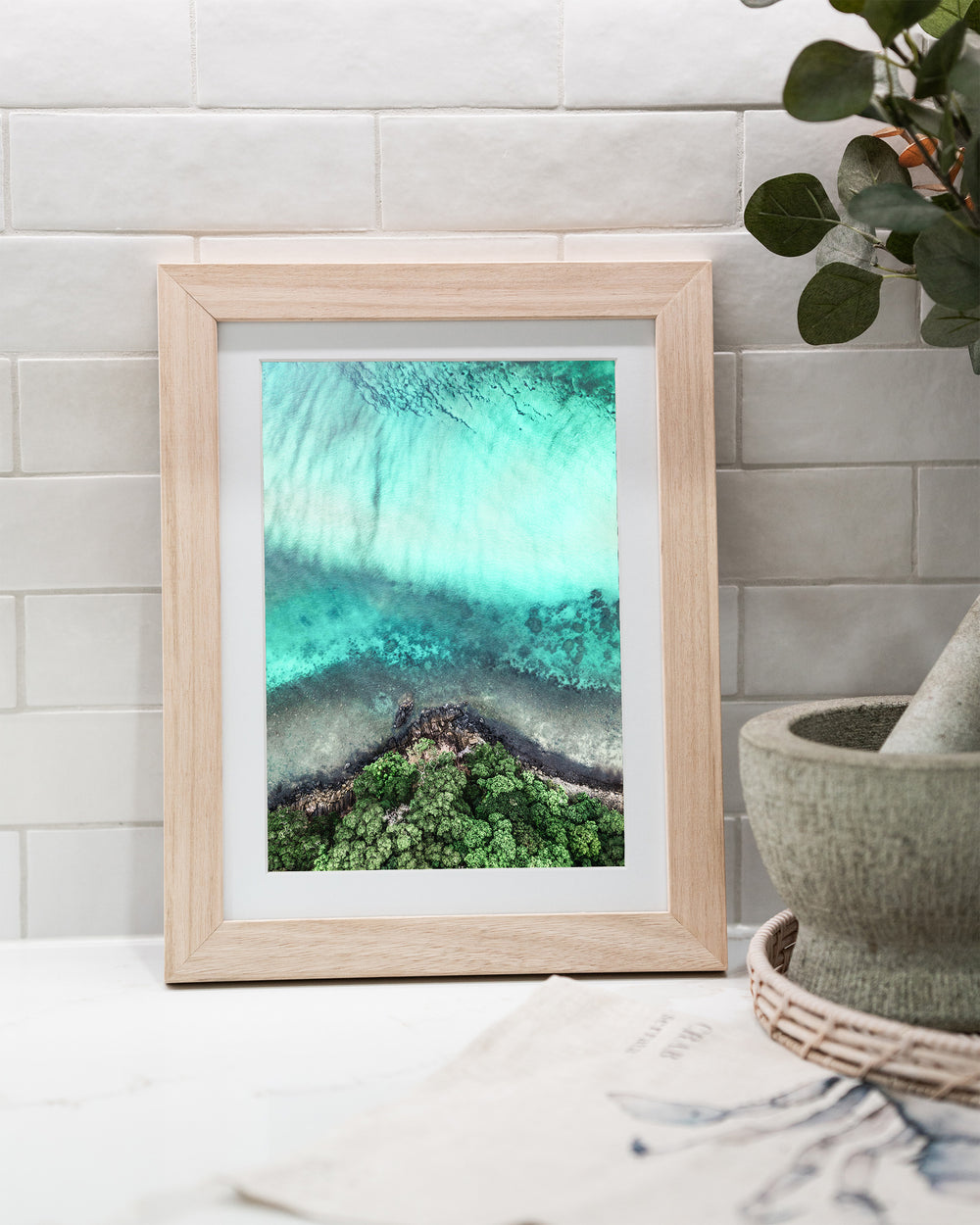 Don’t Dream It’s Over – Cape Tribulation, Aerial Photography by David Lloyd, framed paper print in oak frame, styled in a kitchen bench setting