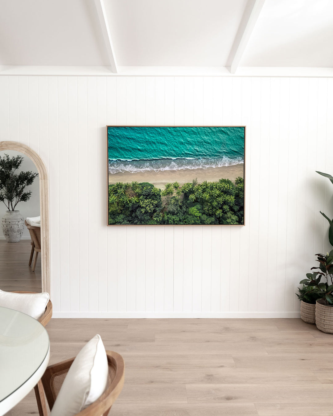 Emerald Tide – Four Mile Beach, Aerial Photography by David Lloyd, framed canvas print in oak float frame, styled in a dining room setting