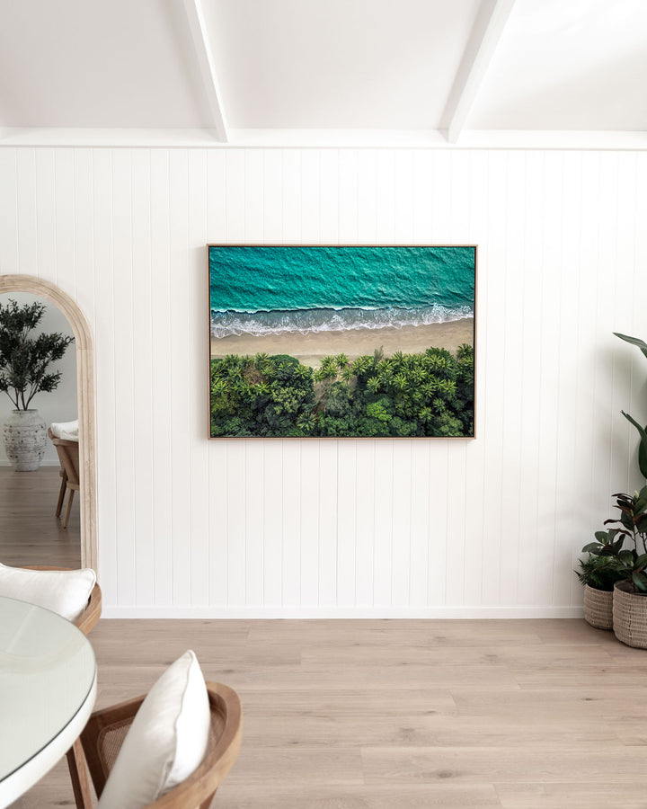 Emerald Tide – Four Mile Beach, Aerial Photography by David Lloyd, framed canvas print in oak float frame, styled in a dining room setting