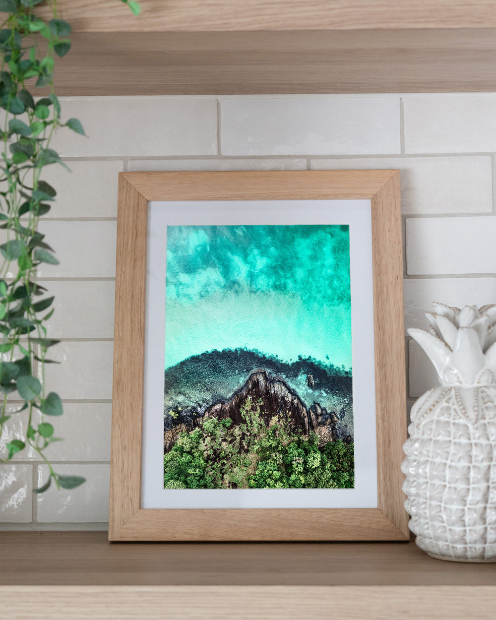 Fall At Your Feet – Cape Tribulation, Aerial Photography by David Lloyd, framed paper print in oak frame, styled in a kitchen shelf setting
