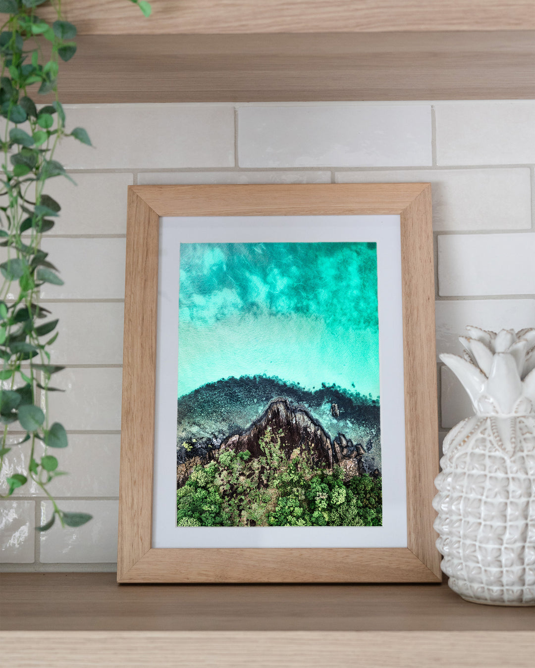 Fall At Your Feet – Cape Tribulation, Aerial Photography by David Lloyd, framed paper print in oak frame, styled in a kitchen shelf setting