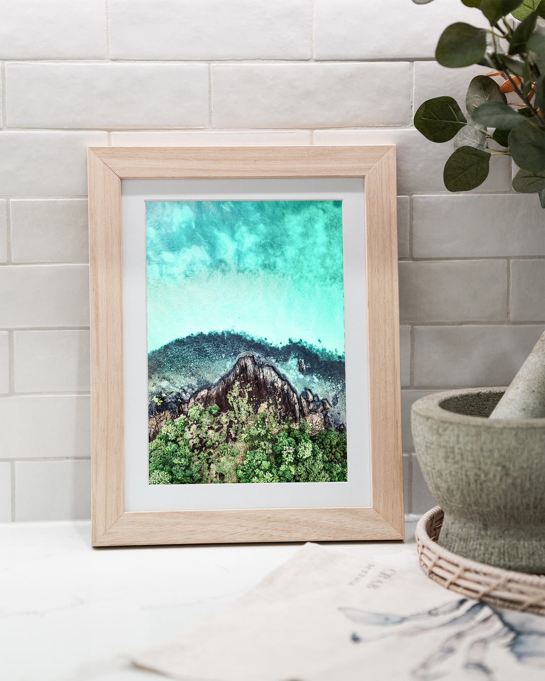 Fall At Your Feet – Cape Tribulation, Aerial Photography by David Lloyd, framed paper print in oak frame, styled in a kitchen bench setting