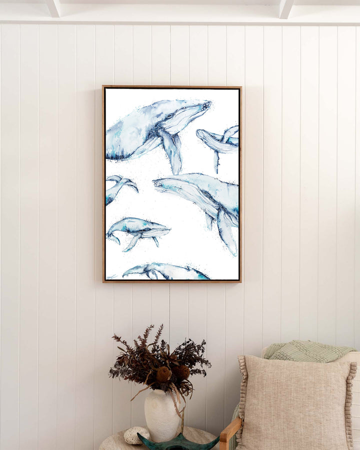 Family Trip humpback whales fine art print by Stephanie Elizabeth, framed canvas in an oak frame in a bedroom