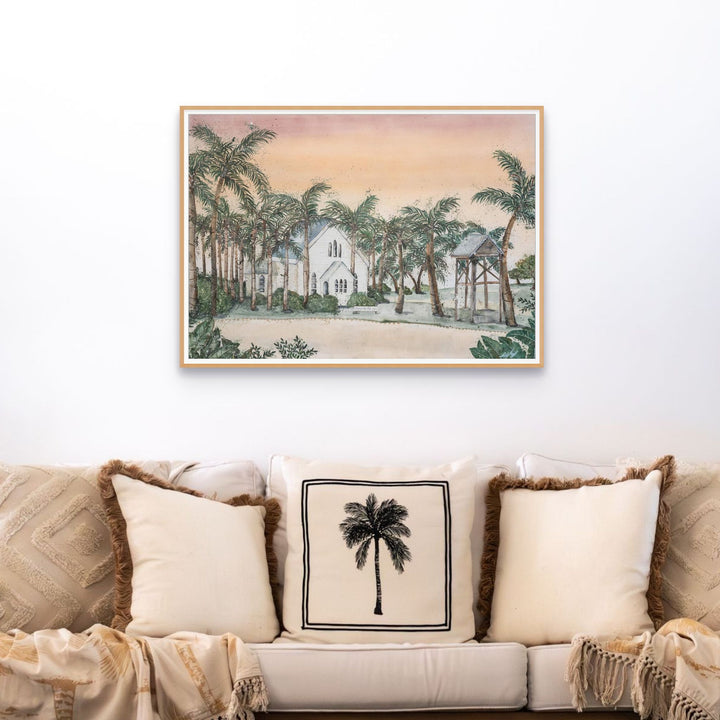 Far Northern Skies print above a beige couch with palm-pattern pillows in a warm, inviting living room.