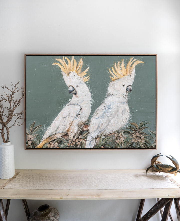Feathers and Mayhem white cockatoo fine art print by Stephanie Elizabeth, framed canvas in an oak frame above a side table