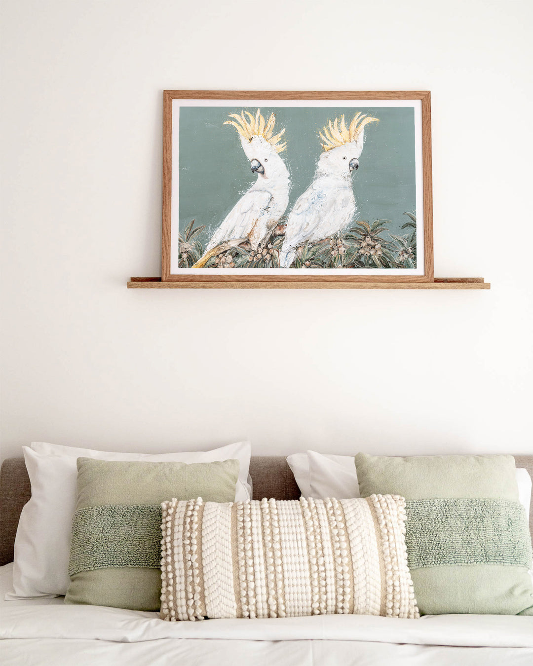 Feathers and Mayhem white cockatoo fine art print by Stephanie Elizabeth, framed paper print in an oak frame in a bedroom