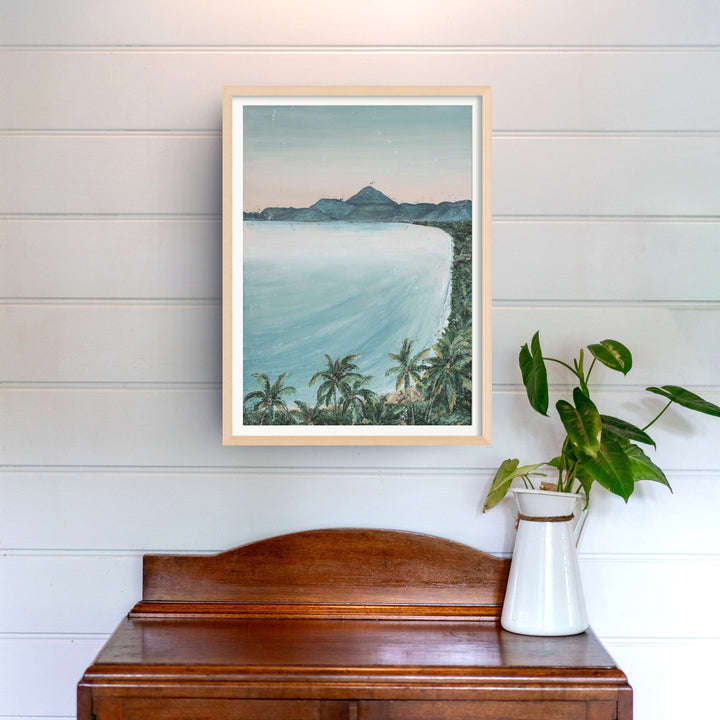From the Lookout landscape print hangs above a wooden table decorated with green plants.