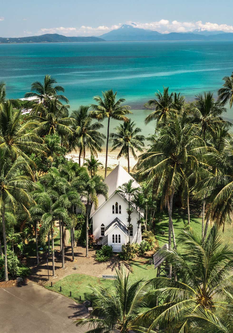 Give Me a Reason to Stay Here – Aerial view of St Mary’s, Port Douglas, with palm trees and a stunning green and blue seascape | Unframed Rolled Print