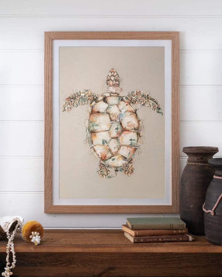 Green sea turtle fine art print by Stephanie Elizabeth, framed paper print in an oak frame on a shelf