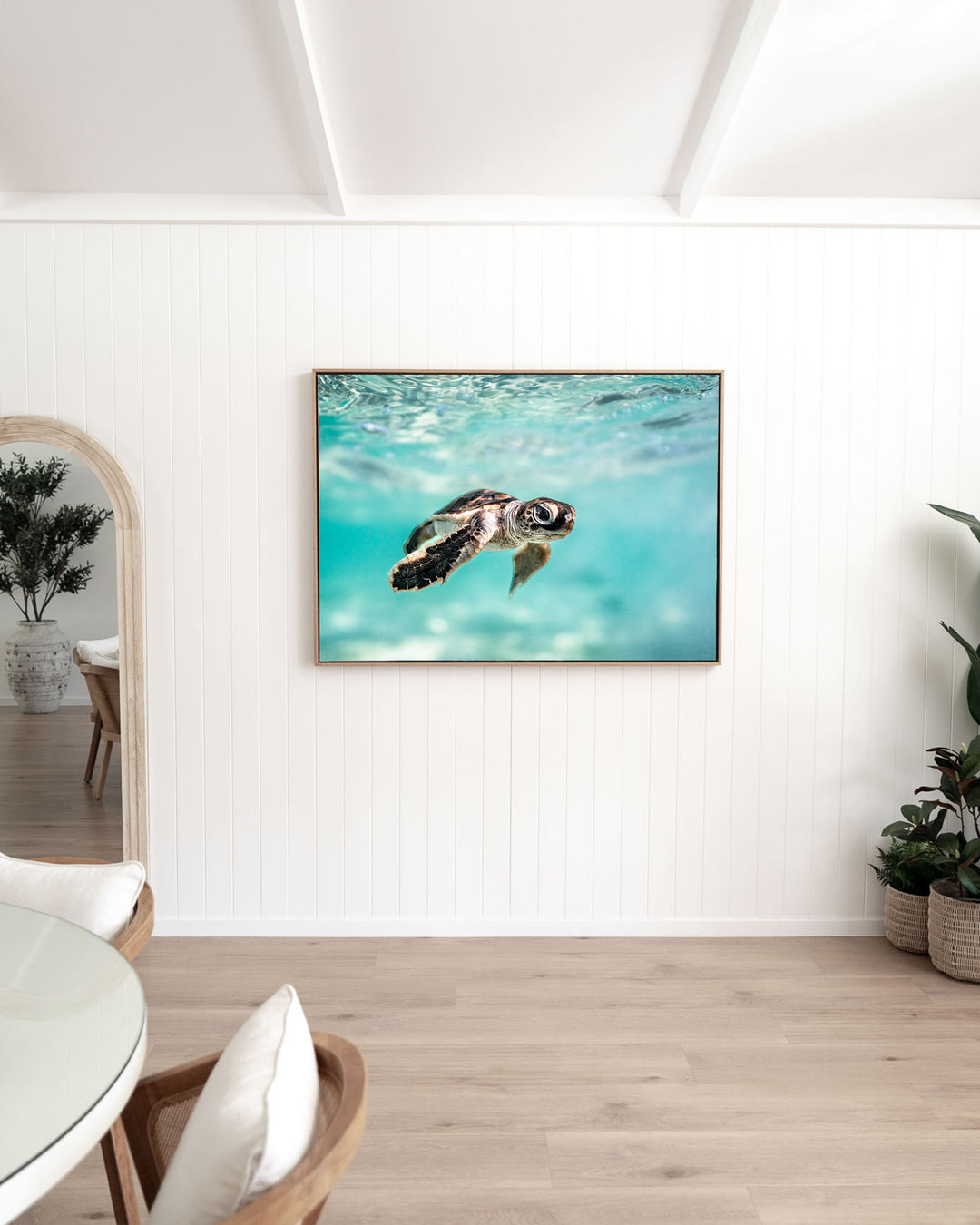 Guided by the Sea – Turtle Hatchling, Underwater Photography by David Lloyd, framed canvas print in oak float frame, styled in a dining room setting