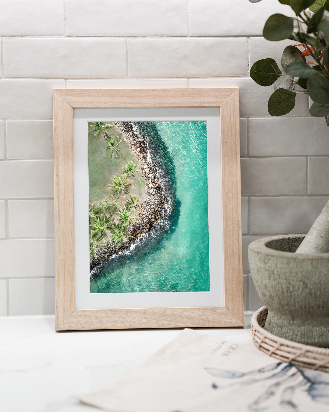 Hammocks and Hangouts – Rex Smeal, Port Douglas, Aerial Photography by David Lloyd, framed paper print in oak frame, styled in a kitchen bench setting