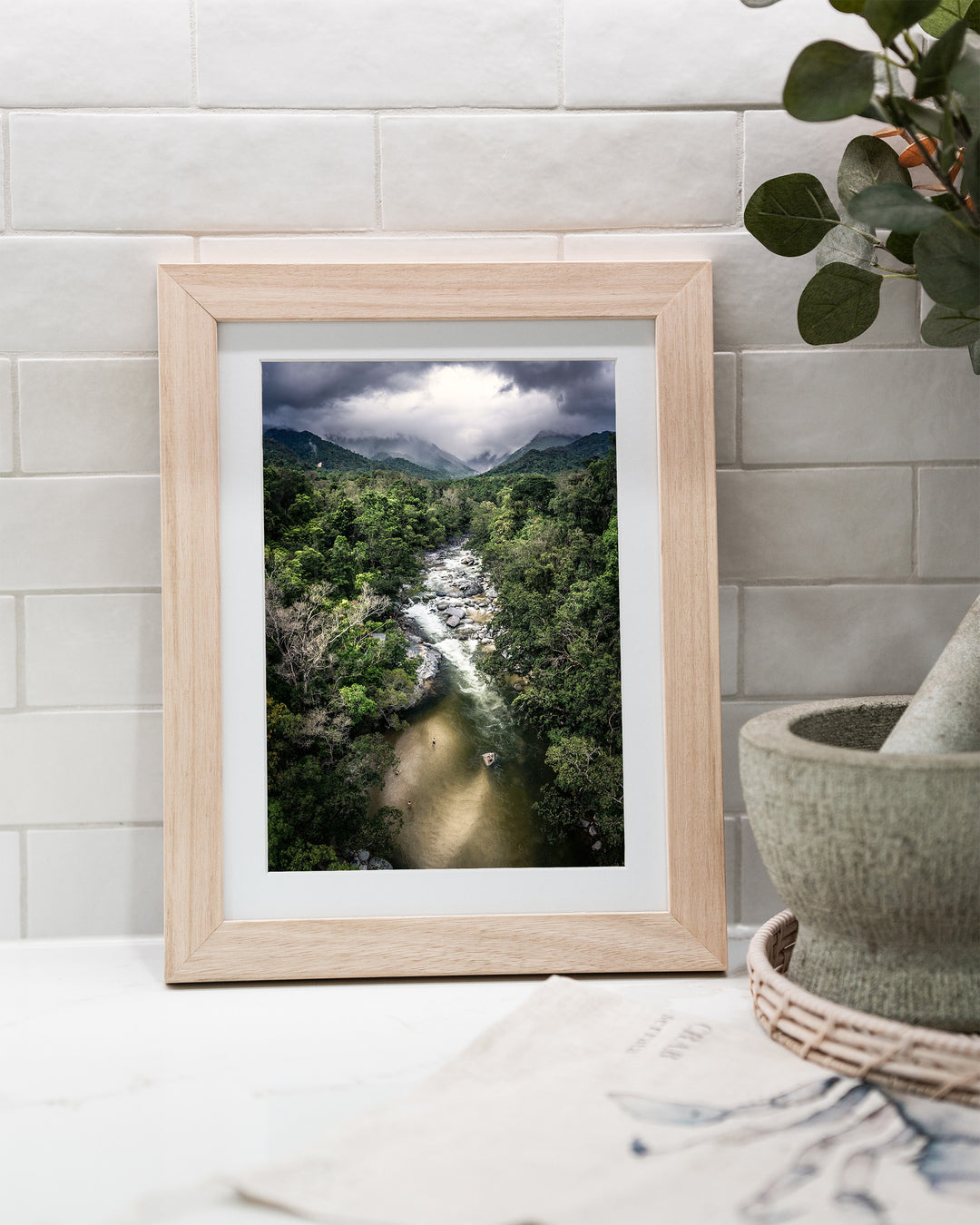 Hazy Habits – Mossman Gorge, Aerial Photography by David Lloyd, framed paper print in oak frame, styled in a kitchen bench setting
