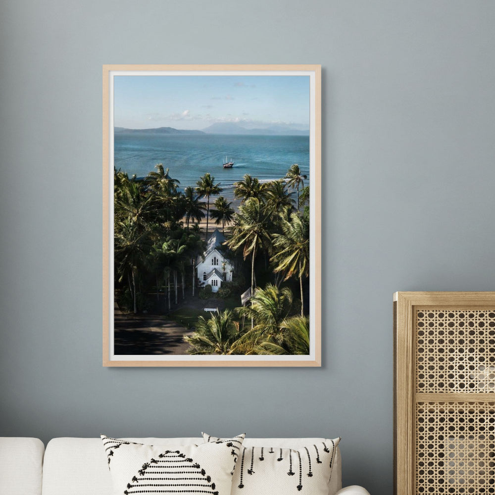 Heading Home – Aerial photograph of St Mary’s Chapel in Port Douglas with palms, ocean views and Shaolin figure in frame | Framed Paper Print