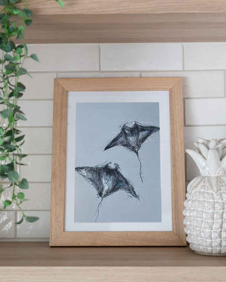 Heart Beats Slow manta rays fine art print by Stephanie Elizabeth, framed paper print in an oak frame on a kitchen shelf