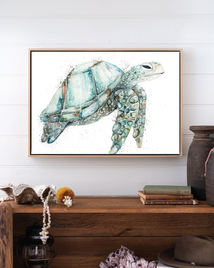 Jade sea turtle fine art print by Stephanie Elizabeth, framed canvas in an oak frame above a bookshelf