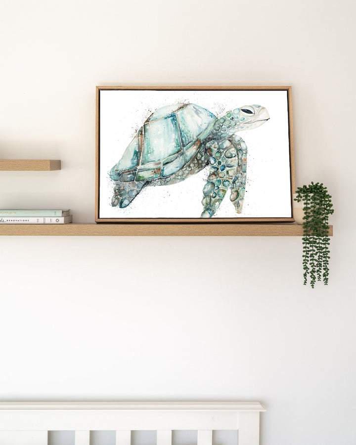 Jade sea turtle fine art print by Stephanie Elizabeth, framed canvas in an oak frame on a shelf