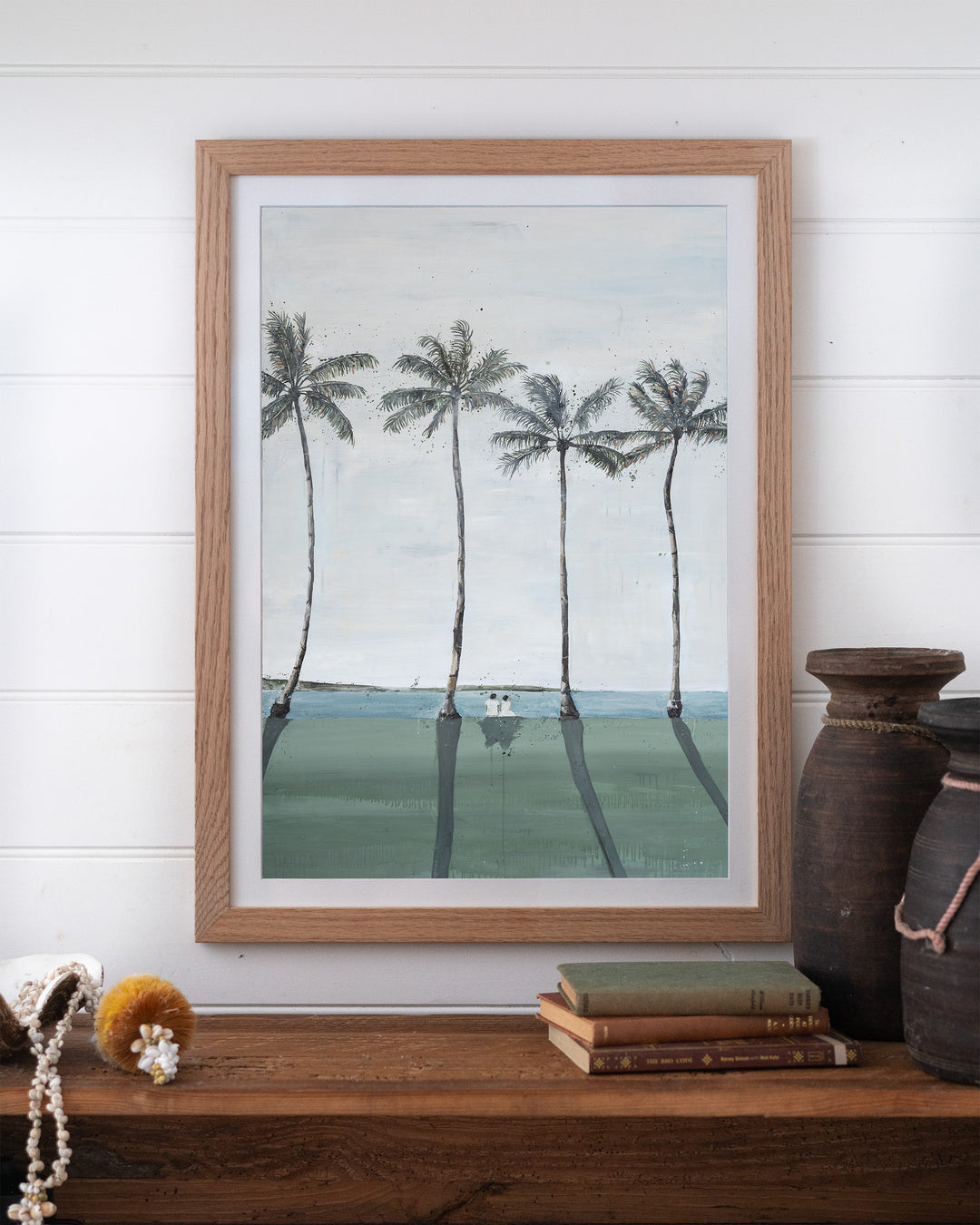 Just Us – palm trees and ocean landscape, framed paper print in oak frame, styled on a timber shelf