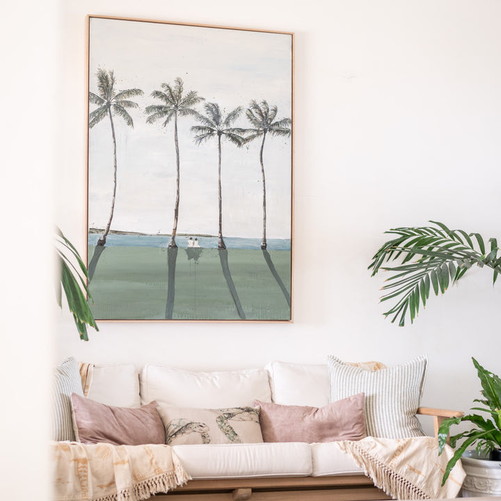 Just Us – original coastal artwork by Stephanie Elizabeth displayed above a sofa in a bright coastal living space with tropical plants