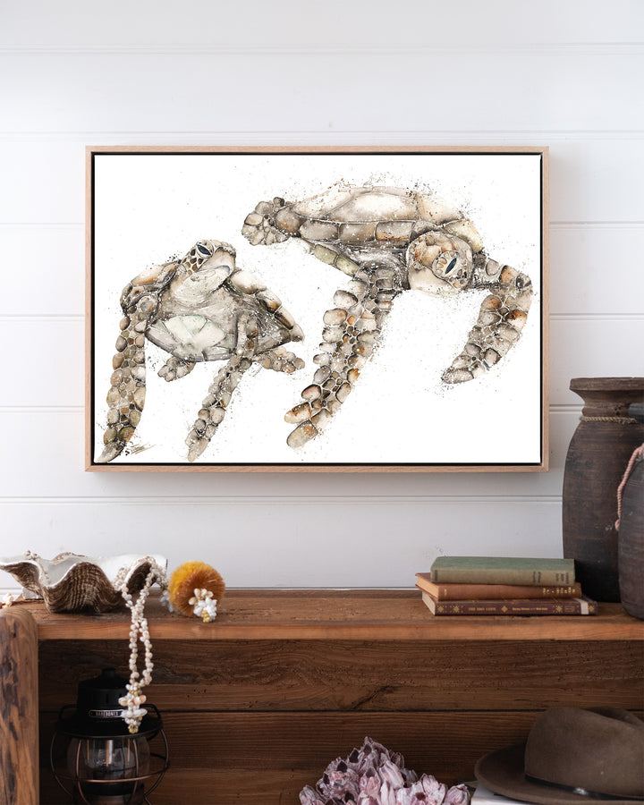Life by Your Side green sea turtles fine art print by Stephanie Elizabeth, framed canvas in an oak frame above a bookshelf