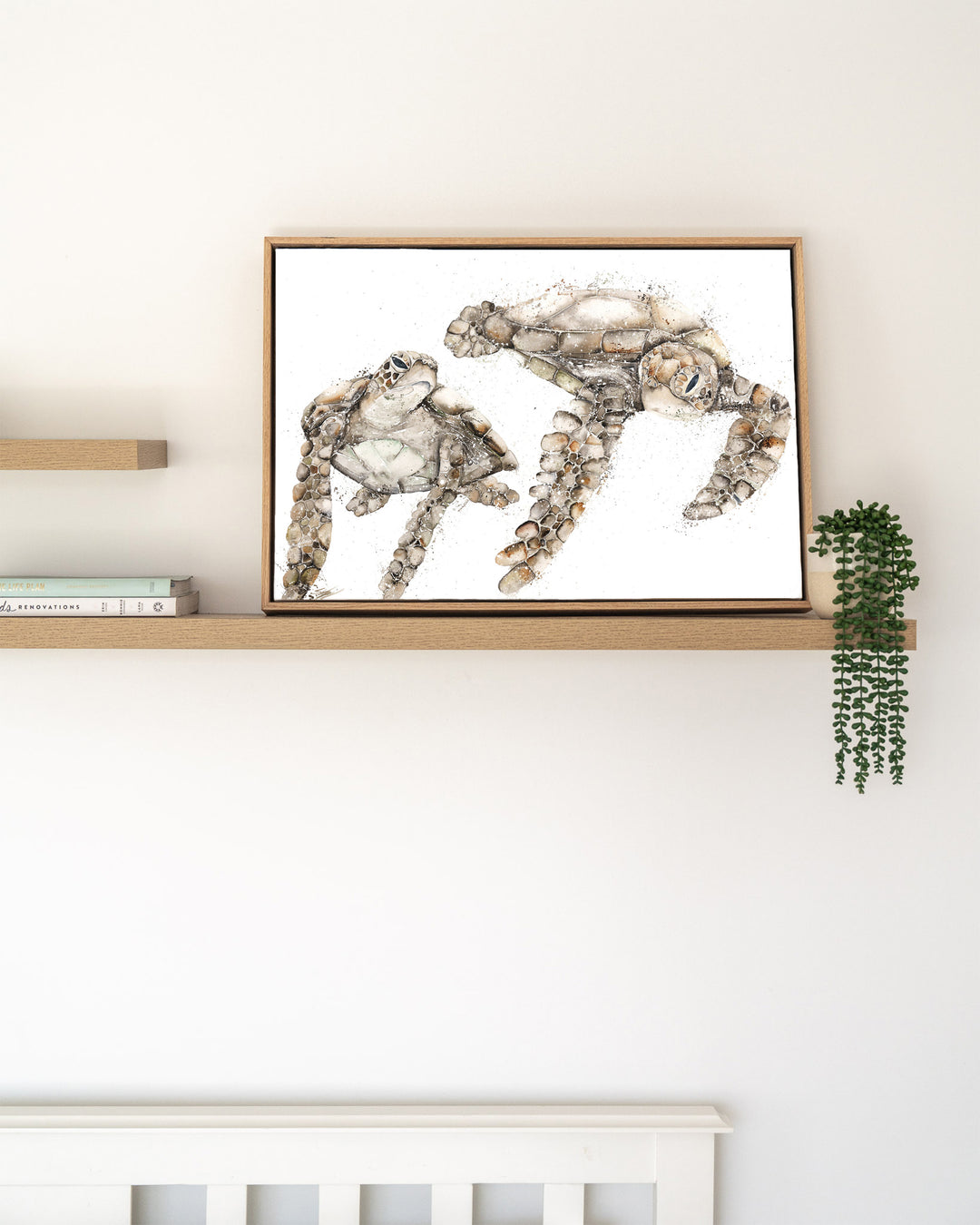 Life by Your Side green sea turtles fine art print by Stephanie Elizabeth, framed canvas in an oak frame on a shelf