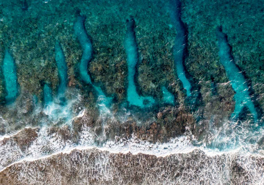 Life On The Edge – Aerial photograph of the Great Barrier Reef with waves crashing over coral formations, intricate reef patterns and turquoise waters | Unframed Rolled Print