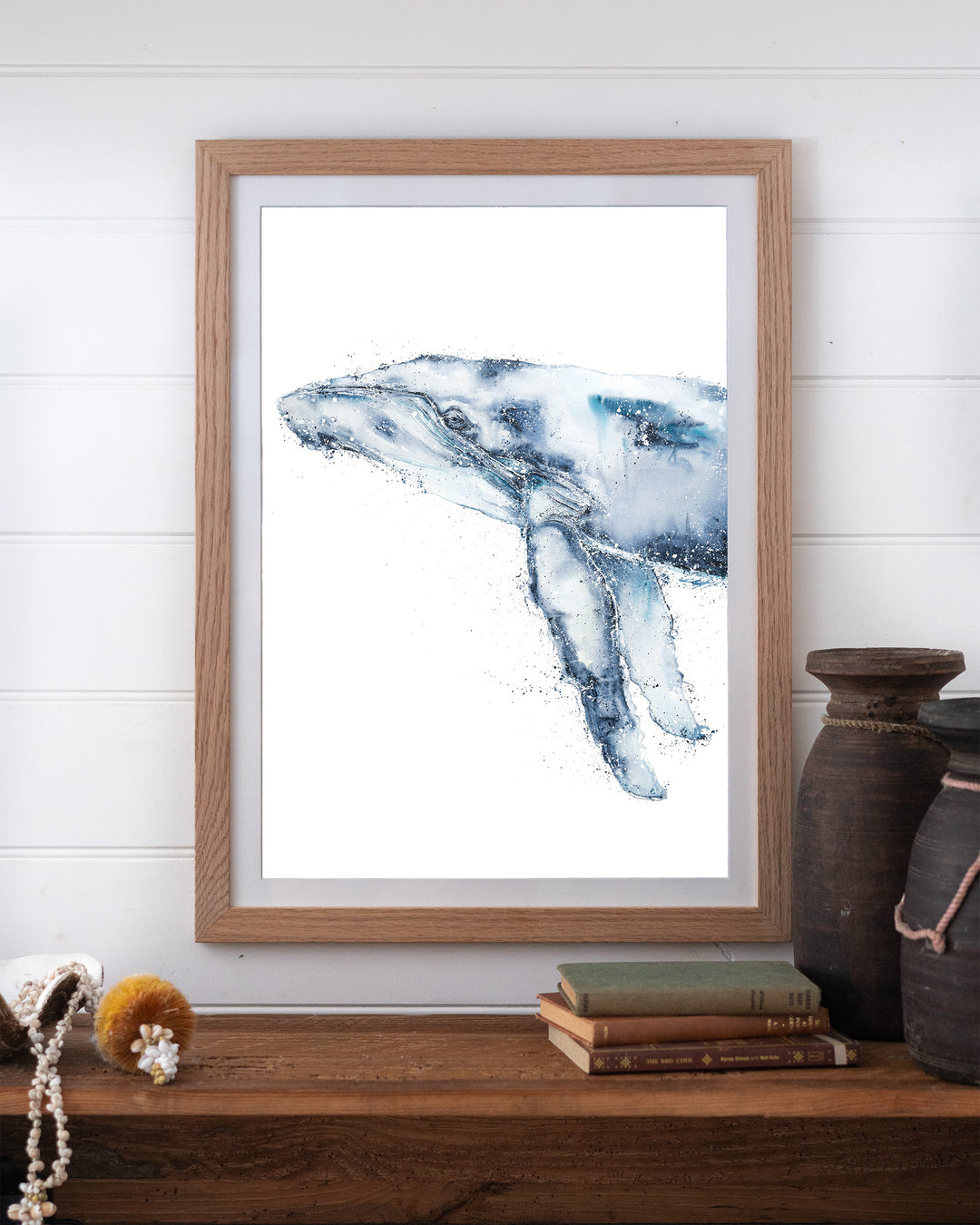 Locking Eyes – humpback whale, framed paper print in oak frame, styled on a timber shelf