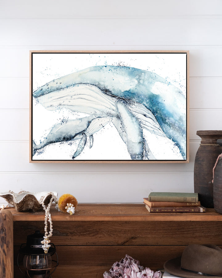 Long Days, Short Years – humpback whale mother and calf, framed canvas in oak float frame, styled above a timber console