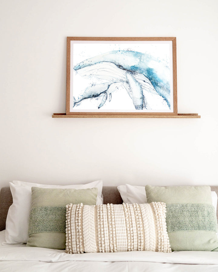 Long Days, Short Years – humpback whale mother and calf, framed paper print in oak frame, styled above a bed