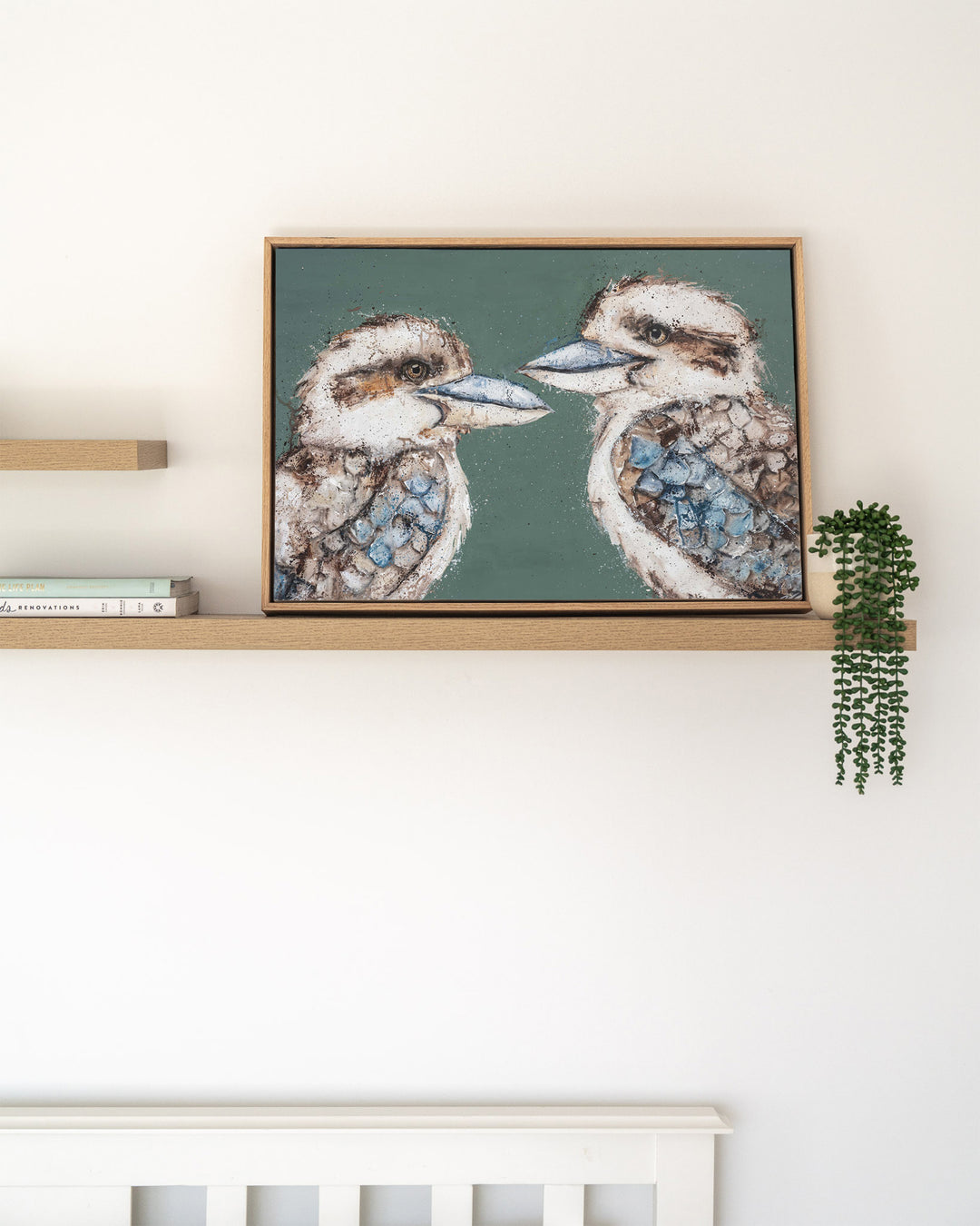 Love Me Now – kookaburras, framed canvas in oak float frame, styled on a floating shelf