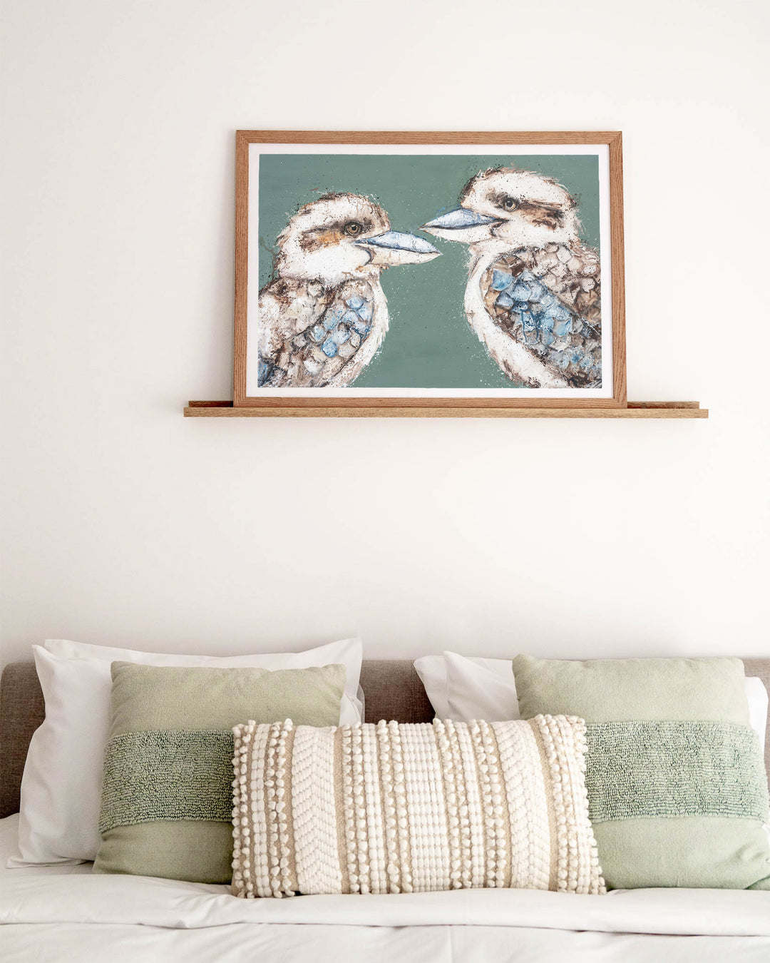 Love Me Now – kookaburras, framed paper print in oak frame, styled above a bed