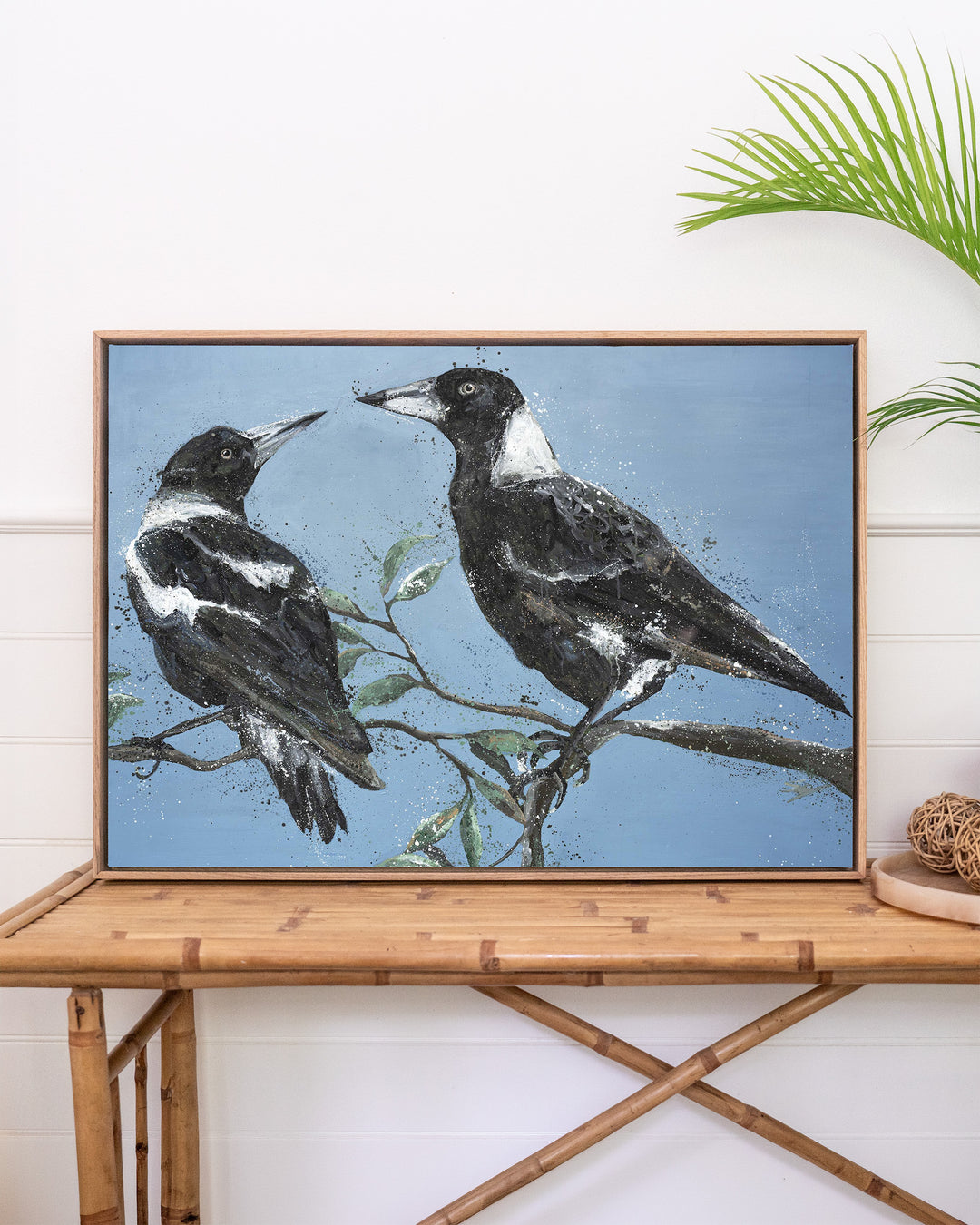 Monochrome Muses – magpies, framed canvas in oak float frame, styled on a rattan table