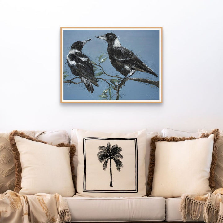 Monochrome Muses | Magpie fine art print above a sofa decorated with a palm leaf patterned pillow.