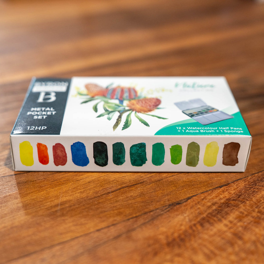 SEA Gallery Nature Watercolour Pocket Set with 12 colors in a small metal case rests on a wooden surface.