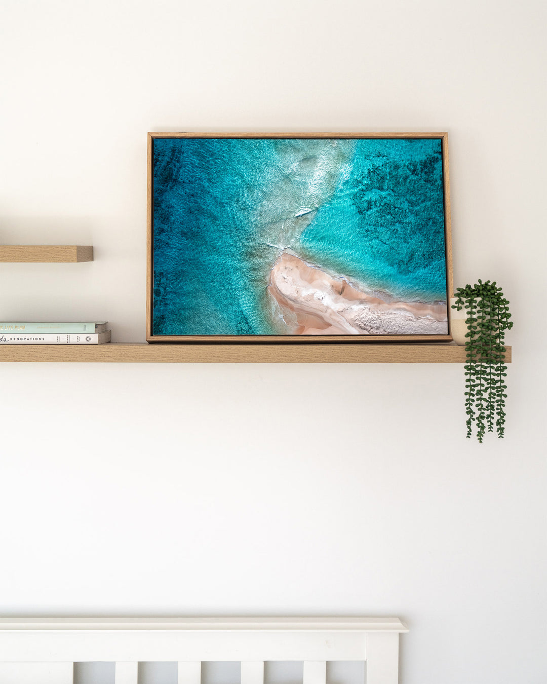 Nothing but Footprints – Ocean Art, Aerial Photography by David Lloyd, framed canvas print in oak float frame, styled in a timber shelf setting