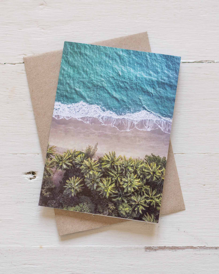 On The Nature of Daylight Greeting Card showing a beach scene, paired with a recycled brown envelope.