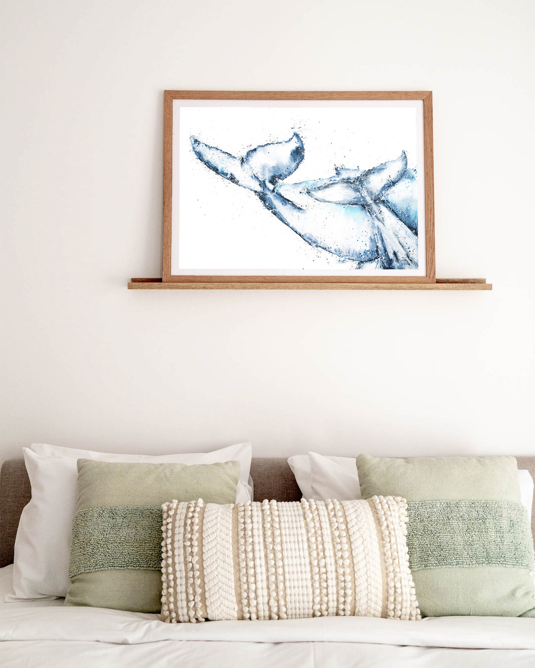 One Tale, Two Tails – whale tails, framed paper print in oak frame, styled above a bed