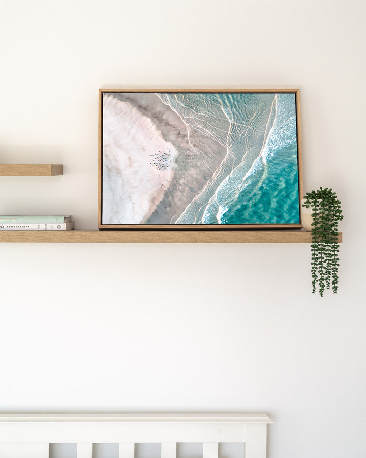 Pearls and Pelicans – Stradbroke Island, Aerial Photography by David Lloyd, framed canvas print in oak float frame, styled in a timber shelf setting