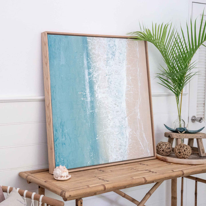 Quiet Shift – coastal aerial painting of shoreline and ocean with long boats styled in relaxed interior with figure for scale by Stephanie Elizabeth | Original Artwork