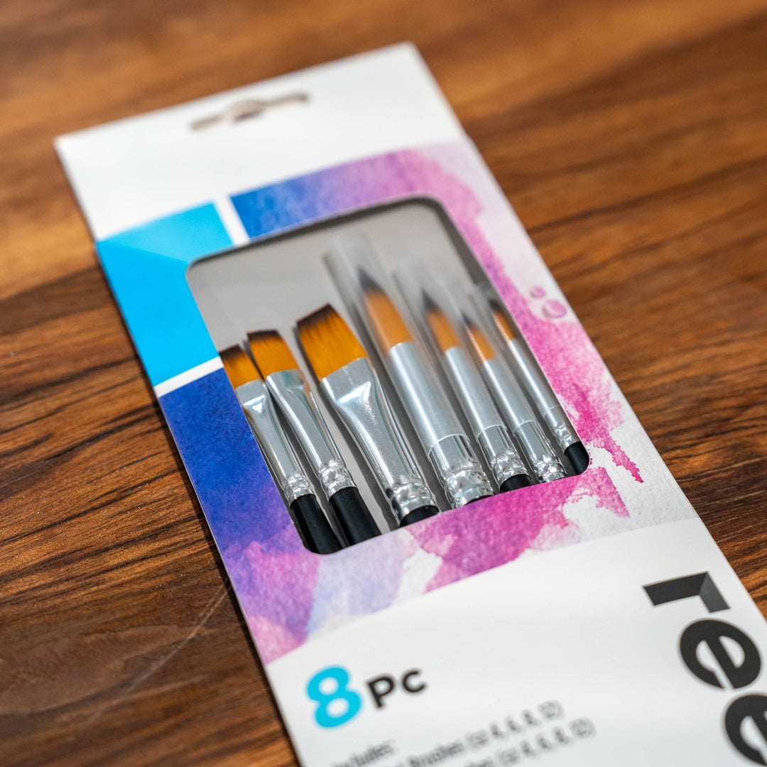 SEA Gallery 8 Piece Brush Set with fine tips in a white and purple box, displayed on a wooden table.