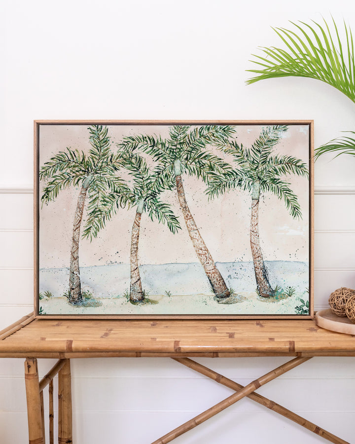 Rex Smeal Serenade – palm trees at Rex Smeal Park, Port Douglas, framed canvas in oak float frame, styled on a rattan table