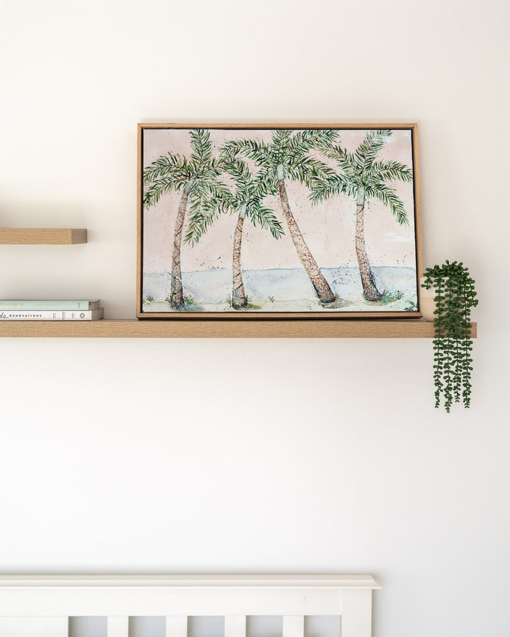 Rex Smeal Serenade – palm trees at Rex Smeal Park, Port Douglas, framed canvas in oak float frame, styled on a floating shelf